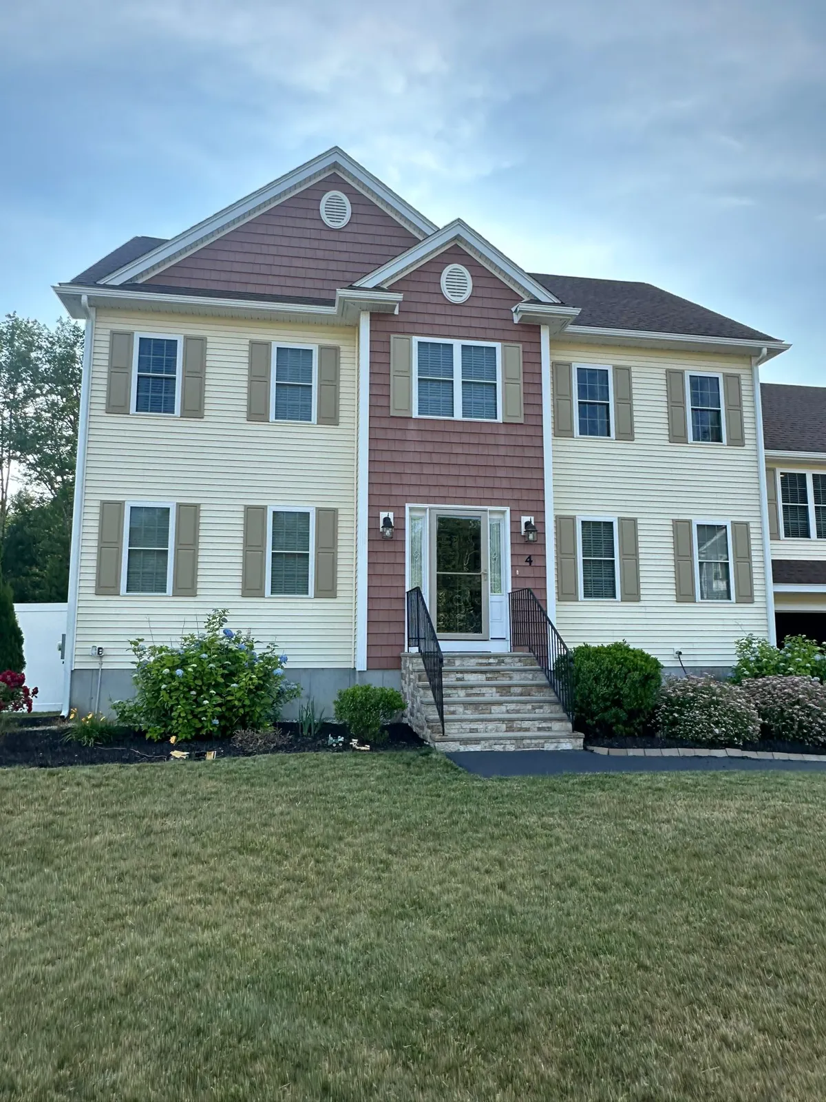 Red and white two-story home with white gutters along each eave