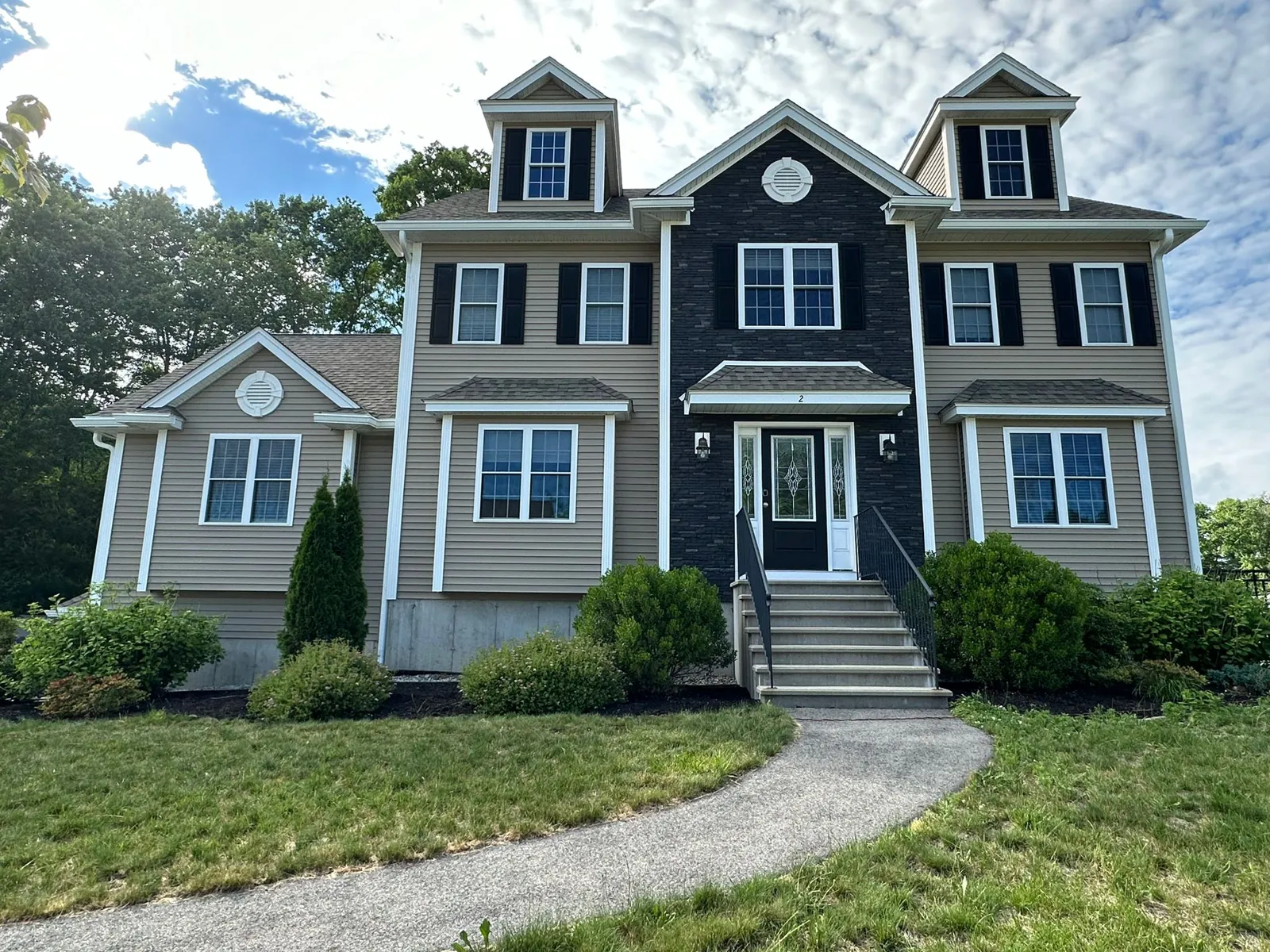 Navy and tan colonial with white gutters above the front entry
